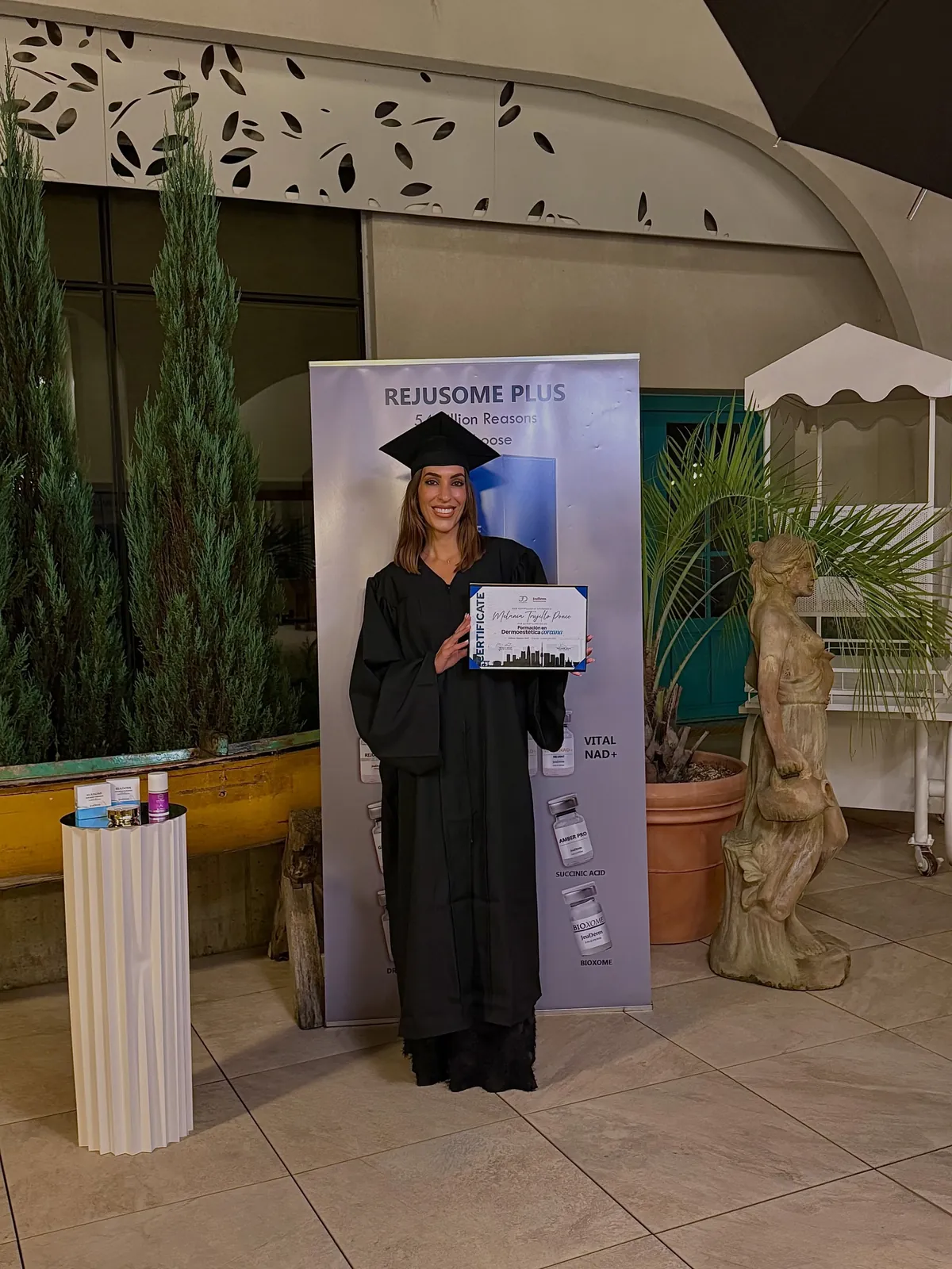 Melania Trujillo con toga y birrete sosteniendo su certificado de especialista en dermoestética coreana